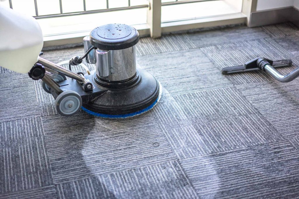 Custodian shampooing a carpet