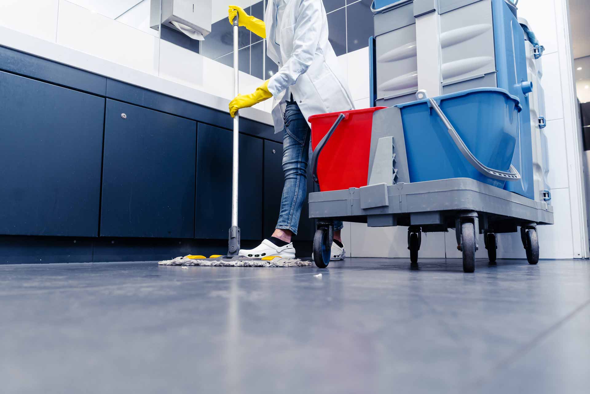 Low-angle shot of janitor mopping public restroom